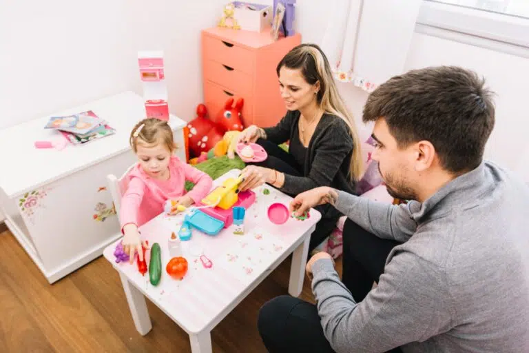 elevated-view-parents-looking-their-daughter-playing-with-toys (1)